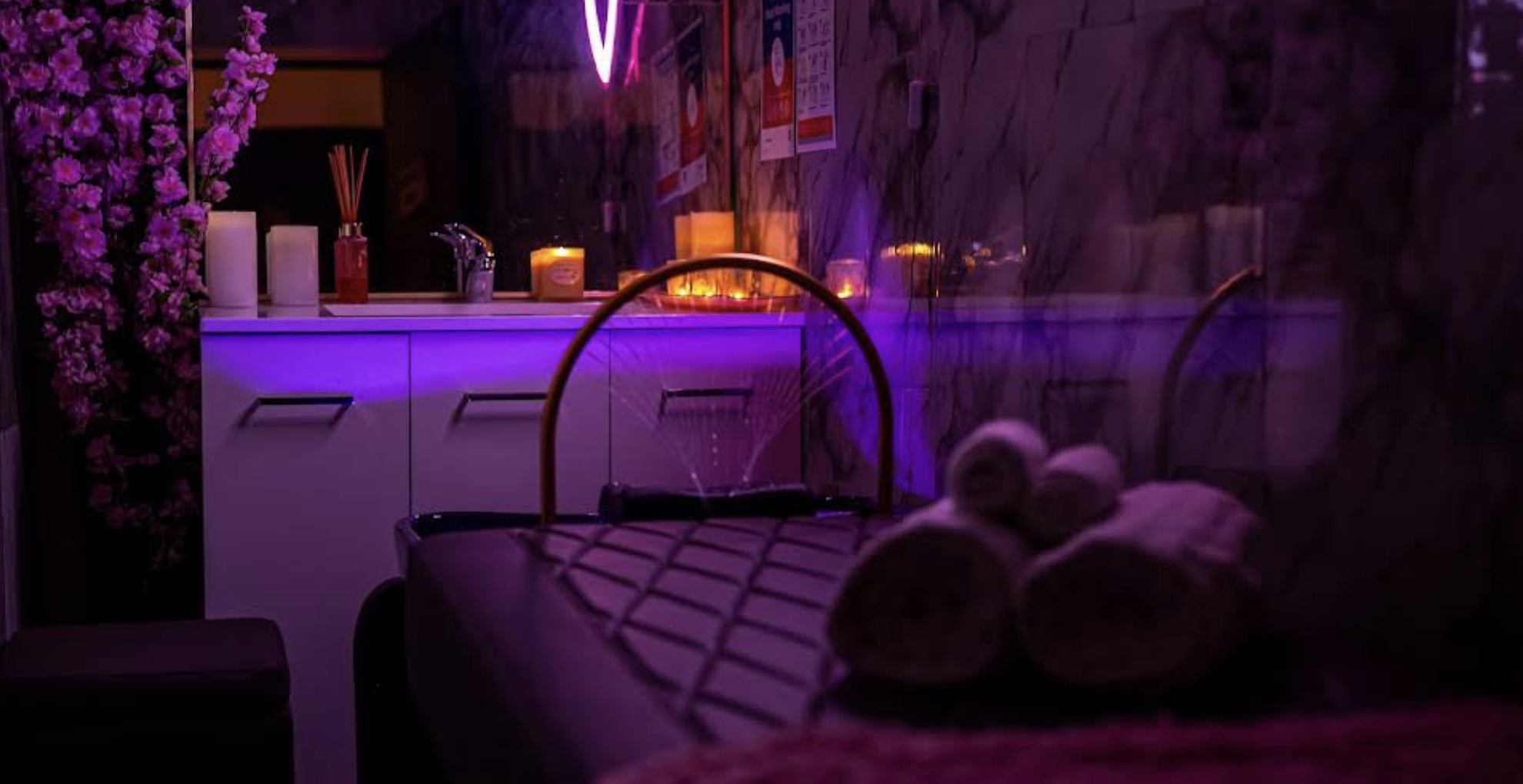 Softly lit treatment room with rolled towels and candles
